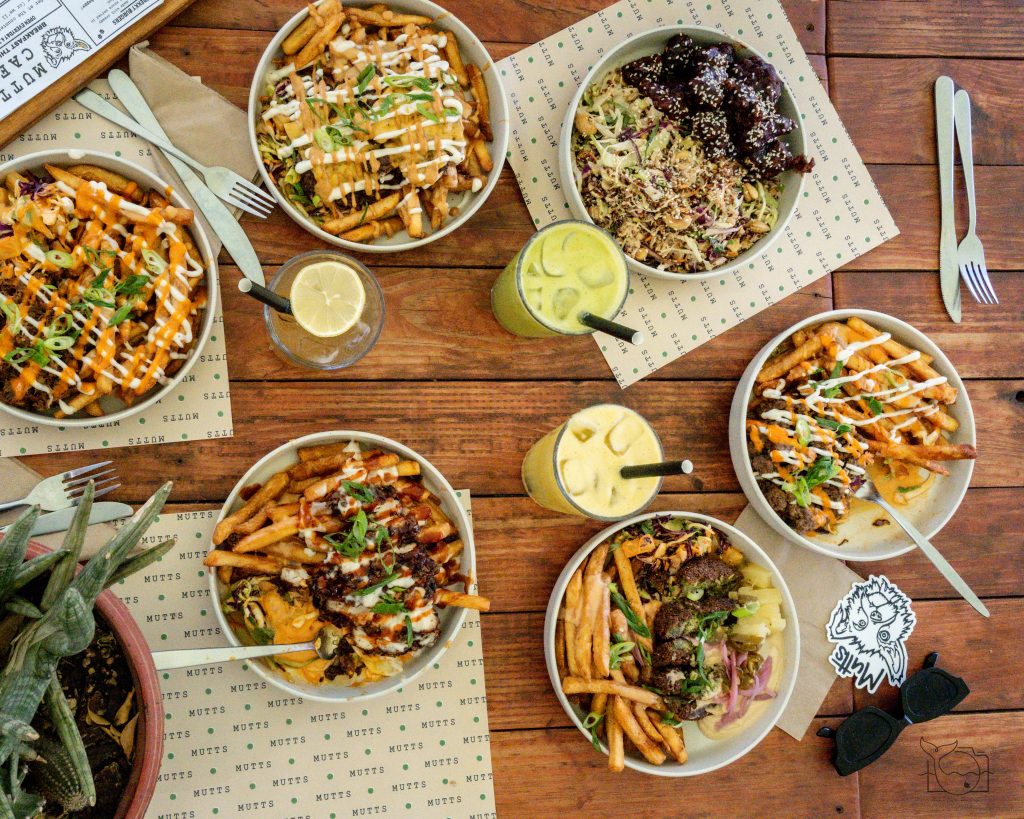 Loaded Bowls & Drinks Table at Mutts Café Exmouth Table outside Mutts Café Exmouth with six loaded bowls and three drinks, perfect for sharing and group dining