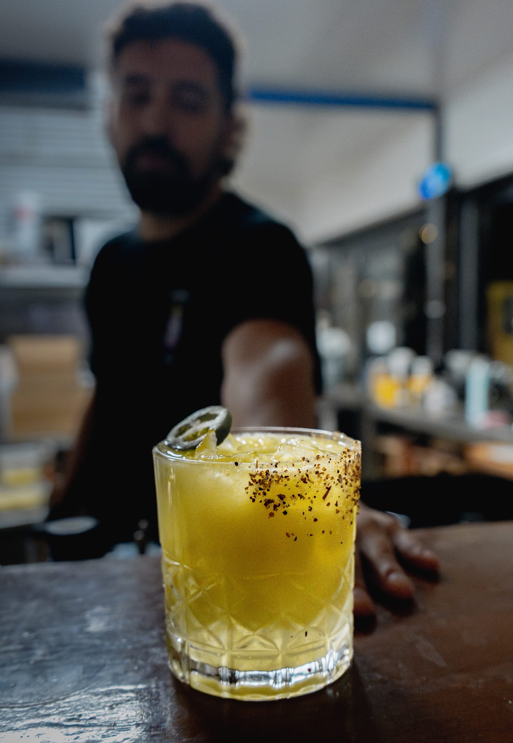 Cocktails Served at Mutts Café Exmouth Cocktail being passed over the bar counter at Mutts Café Exmouth with staff blurred in background. Hospitality jobs Exmouth WA