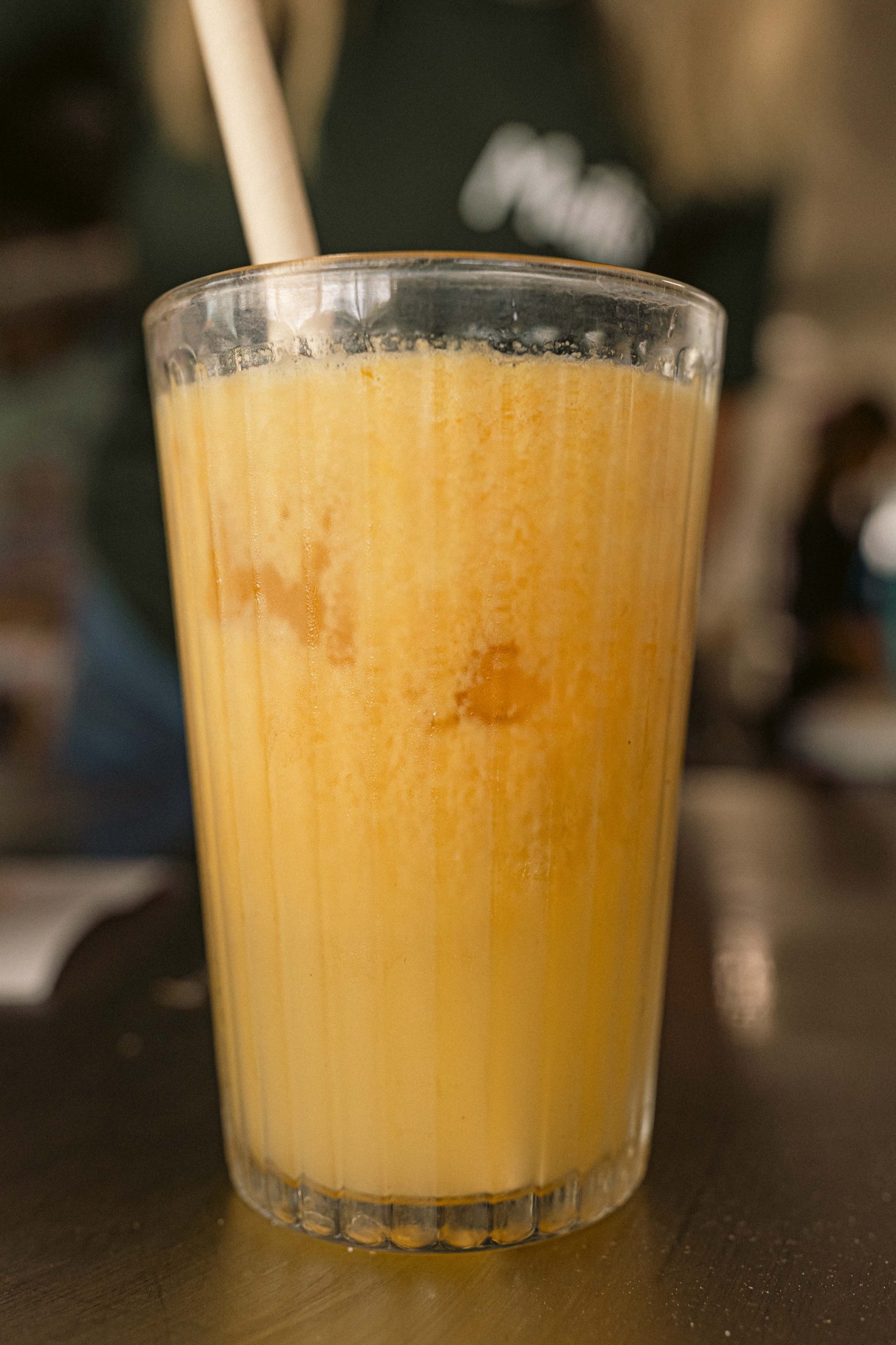 Fresh Orange Juice at Mutts Café Close-up of fresh-squeezed orange juice in a glass, sitting on a bench outside at Mutts Café. Drinks Menu Exmouth
