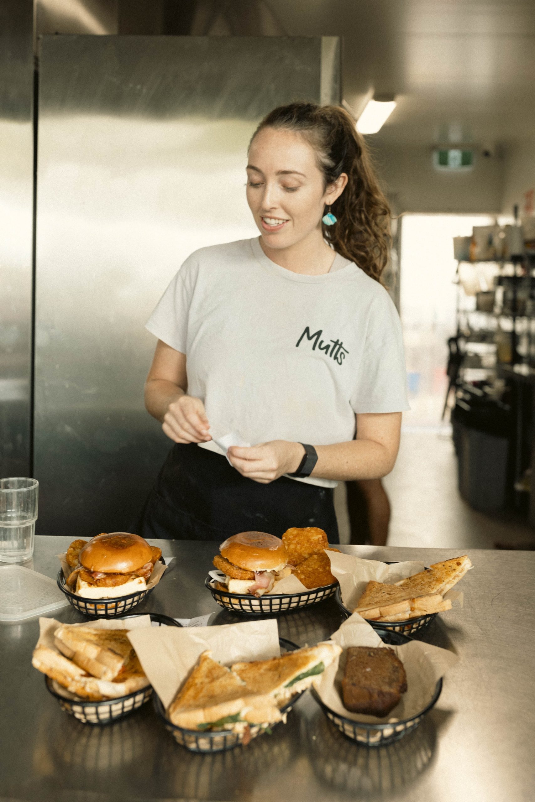 Fresh Food Ready to Go at Mutts Café Exmouth Staff holding burgers and toasties at the kitchen window at Mutts Café Exmouth. Hospitality jobs Exmouth WA