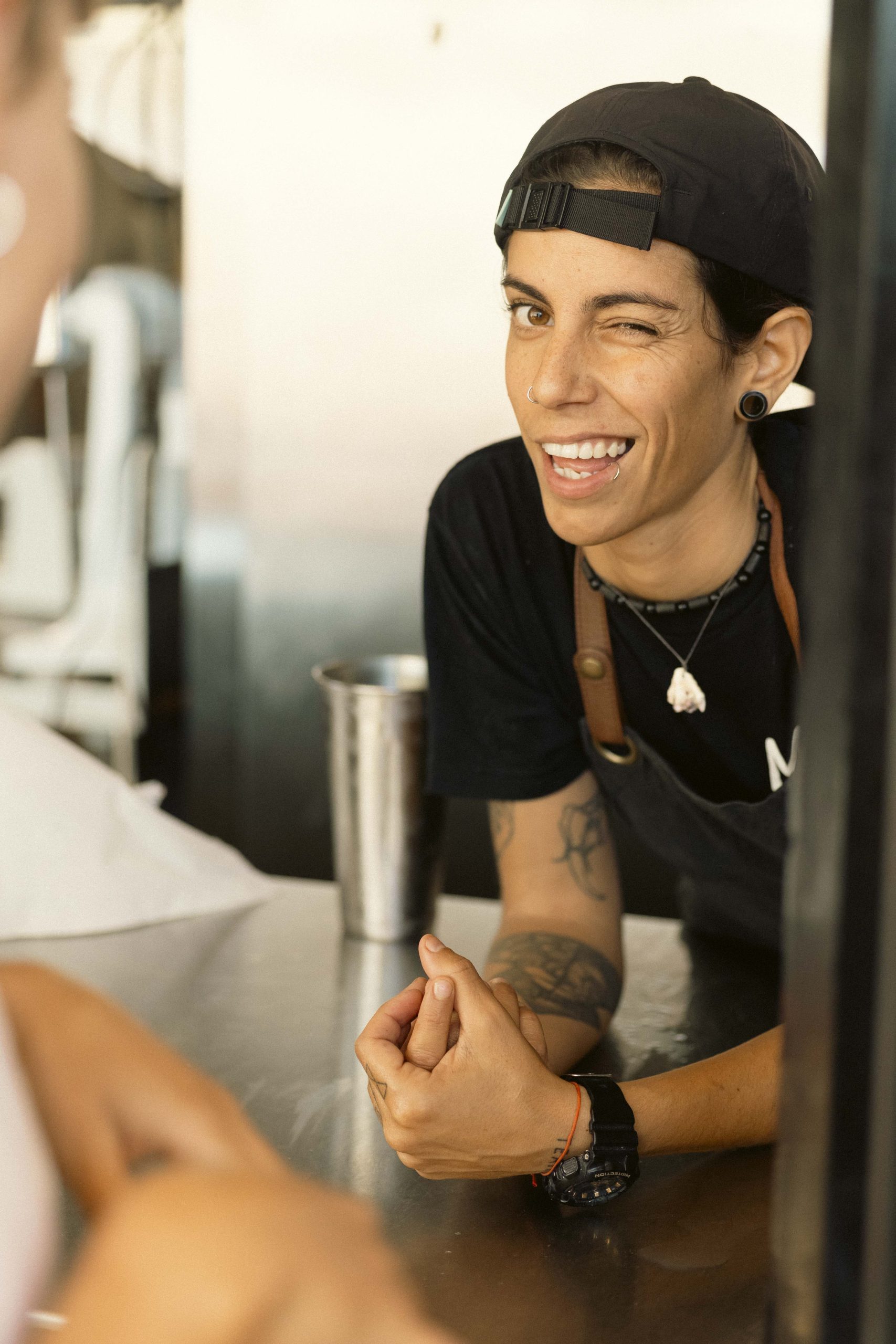 Behind the Scenes at Mutts Café Exmouth Hospitality jobs Exmouth WA. Smiling kitchen staff winking behind the counter at Mutts Café Exmouth